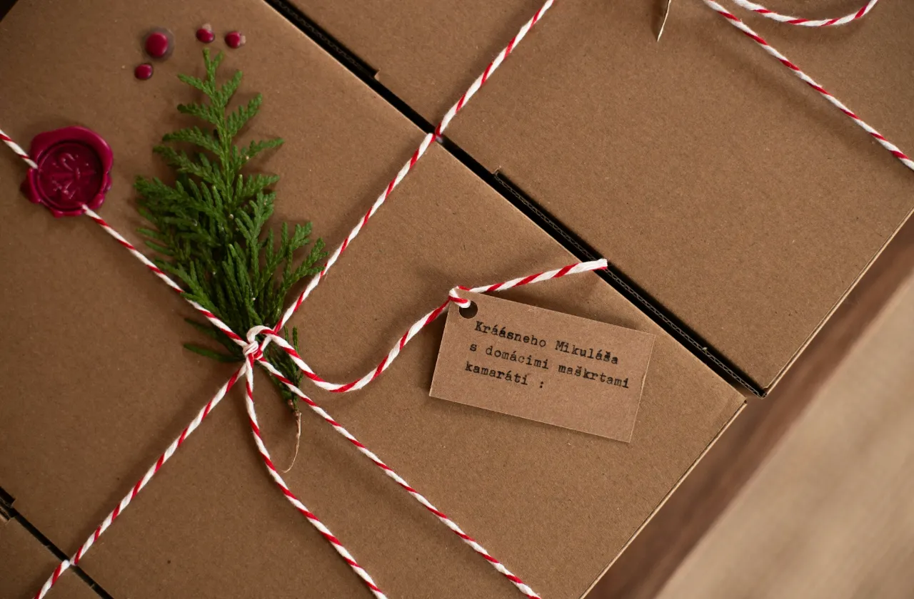 Shipping boxes tied with red and white twine and a sprig of pine