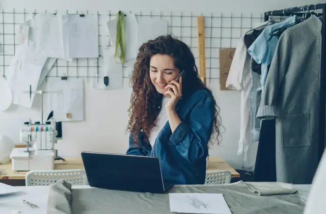 Small business owner on the phone while working on a laptop